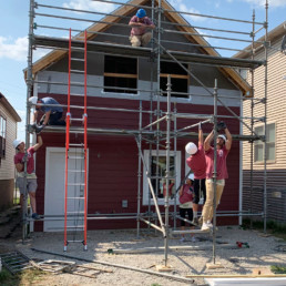 Photo of people constructing back of a house