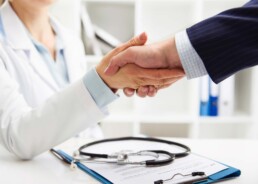 photo of physician shaking hands with business person